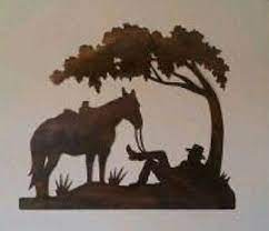 It features a cowboy hat that is circled with a lasso. Rustic Cowboy And Horse Under Tree Western Metal Wall Art Original Home Decor Pirografia Arte Pinturas