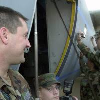 Technical Sergeant (TSGT) Joe Carter, USAF, (left) and MASTER Sergeant  (MSGT) Ronald Keeney, USAF, stand by the EC-130E Hercules number 63-7783  along all the signatures of unit members after a decommissioning ceremony.
