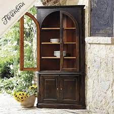 It's built from solid mango wood in a dark brown finish with riveted accents around the edges for a healthy dose of rustic charm. Casa Florentina Gabriele Corner China Cabinet In Antique Mahogany