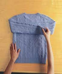 With the sweater face down, fold the sleeve in toward the center of the sweater. How To Fold A Sweater Real Simple