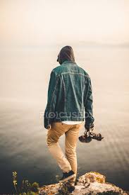 To blur a running person start with 1/60th of a second. Man With Camera Walking On Promontory Freedom Hooded Jacket Stock Photo 203407780