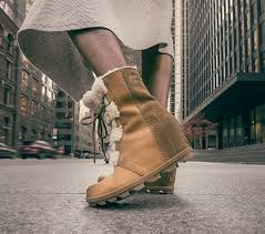 Sorel For Women Walking Across The Street Wearing Joan Wedge Shearling Boots Close Up Of Boots Shearling Boots Joan Of Arctic Wedge Boots