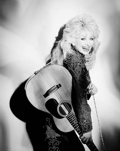 Dolly Parton, Manhattan NY, 1994. Dolly walks in in this gingham dress with her guitar strapped on her, denim jacket covered in rhinestones, and she is so country—just the epitome of country—but