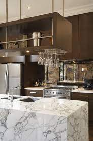 Kitchen islands typically stand alone and offer ample counter space and plenty of cabinet storage. Marble Island Bench With Overhead Glass Rack Ravida Property With Distinction Modern Kitchen Storage Kitchen Island Storage Transitional Kitchen Design
