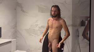 A man naked and alone in the bathroom takes his erotic shower