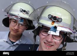 Darmstadt, Germany. 28th Mar, 2019. Thomas Greb (r) and Khanh An Do from  the Ludwig-Geißler-Schule in Hanau present fire helmets with head-up  display and infrared camera at the state competition of "Jugend