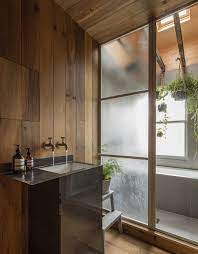 The floors are well tiled and the furniture has a shiny polish on. A Japanese Style Two Room Bath Filled With Hanging Plants