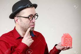 Adult Man Wearing Funny Hat And Eyeglasses Holding Small Red House Model.  Guy Being Real Estate Agent. Home Ownership Concept. Stock Photo, Picture  and Royalty Free Image. Image 135733551.