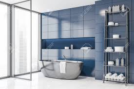 White or blue linens pick up colors used in the mosaic without looking abrasive (as orange might). Corner Of Stylish Bathroom With Blue Tile Walls White Tile Floor Stock Photo Picture And Royalty Free Image Image 127790061