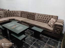 كنب رمادي وطاولات خشبي