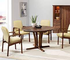 A reclaimed oak and chestnut burl restored circular extending dining table, the segmented top opening to reveal six self storing fold out leaves above a plain frieze, on a vase column support and crossover refectory feet. Traditional Round Dining Room Table Wharfside Danish Furniture