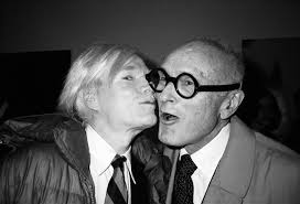 Philip Johnson, a pioneering architect in modern and postmodern  architecture, was often seen with artists like Andy Warhol, a seminal  figure in the Pop Art movement. The photo is a striking visual