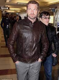 The Butler Did It Gerard Reveals A Little Too Much Derriere As He Bends Down To Remove His Shoes For Airport Security Gerard Butler Brown Fall Jacket Leather Jacket