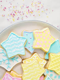 Two children in kitchen decorating cookies smiling. Star Cookies With Royal Icing Into The Cookie Jar