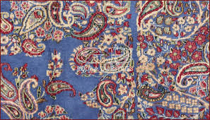 A kirman 'vase' carpet fragment south east persia, early 17th century the light blue ground with scrolling interlaced sandy yellow and burgundy scrolling split palmette arabesques overlaying a variety of delicate floral sprays, one side with a burgundy border of interlaced indigo and ivory arabesques with inner reciprocal yellow and light blue trefoil stripe, slight insect damage and holes Alter Kirman Teppich 398x295 142000431380