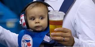 Baby stares at beer at baseball game
