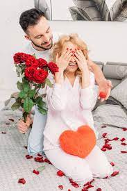 Learn how to ask questions to get more detail about type and cost when shopping in english. Man Making Proposal And Presenting Flowers To Girlfriend In Bedroom Stock Photo Picture And Royalty Free Image Image 118997293