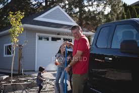 Most of the cars and trucks are working vehicles with busy schedules. Father And Daughter Having Fun While Washing Car Outside Garage Casual Clothing Cleaning Equipment Stock Photo 209282684