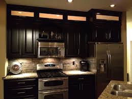 Gray quartzite countertops and backsplash with espresso cabinets. Espresso Cabinets Light Granite Stacked Rock Backsplash With In Cabinet And Under Cabinet Lighting Stacked Stone Backsplash Backsplash Stone Backsplash