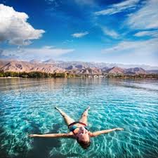 Woman Laying Like A Star In Issyk Kul Lake At Mountains Background Asia Travel Places To Go Places To See