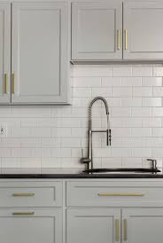 Brass Modern Cabinet Hardware Gray Cabinets Black Countertop White Subway Tile Design Manifest Kitchen Renovation Kitchen Cabinet Design Kitchen Remodel