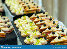 Desayuno tardío de bar, refrigerio sencillo entre horas, almuerzo de recreo, compañero de viajes y excursiones. Canapes Con Queso Y Uvas Y Bocadillos Con Tocino Y Col Y Tomates Con Las Aceitunas En Un Pincho En Una Tabla De Comida Fria Foto De Archivo Imagen De Comida