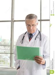 Middle Aged Doctor Reading Chart Stock Photo Image Of