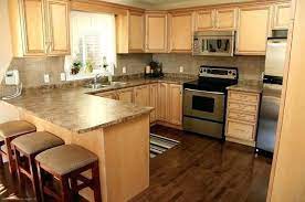The white marble countertops and cream colored cabinets pop against the dark wood of the island and floor. Maple Kitchen Cabinets With Dark Wood Floors Maple Kitchen Cabinets Light Wood Cabinets Hardwood Floors In Kitchen