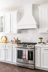 Beach style kitchen with white heringbone backsplash gray cabinet. All White Kitchen Remodel Edit By Lauren