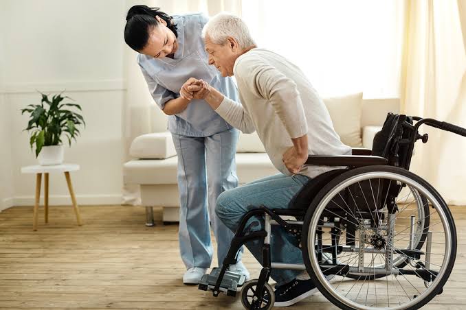 Caregiver assisting a client using a wheelchair inside the home