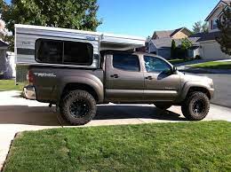 The clamps slide under the rails of the truck bed and around the lip. Adventure Truck Retrofitted A Toyota Tacoma With A Bed And Drawer System For Climbing And Adventuring Pickup Camper Toyota Tacoma Accessories Truck Bed Camper