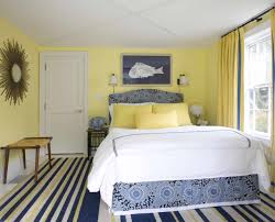 A moody bedroom with graphite grey walls, a grey paneled wall, heavy furniture, yellow and white bedding a parisian style bedroom with grey paneled walls, an upholstered bed, round nightstands, a yellow floral carpet and a crystal chandelier Yellow And White Bedroom Houzz