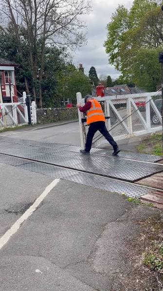 Preparing for a steam locomotive to pass through the level crossing. , This is the Church Lane level crossing near Matlock, Derbyshire, in England. , The steam locomotive is a Peckett & Sons Ltd tank ...