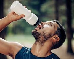 Image of person drinking water from a reusable bottle