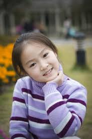 Beautiful Young Girl Standing Under Wisteria Vines Stock Photo