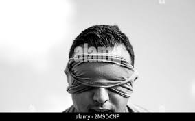 U.S. Air Force Staff Sgt. Brandon Peralta, a defender assigned to the 6th  Security Forces Squadron, is blind folded during an M-4 Carbine rifle  assembly challenge as part of National Police Week