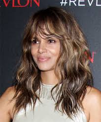 This wavy blunt haircut with feathered center bangs is so chill you just might not notice the heat this summer. Halle Berry Long Wavy Brunette Hairstyle With Layered Bangs