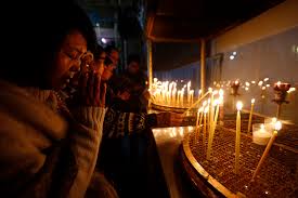 A Christian Worshipper Prays After Lighting A Candle At The Church Of The Nativity Built Atop The Site Where Christians Believe Jesus Christ Was Born On Christmas Eve In The West Bank