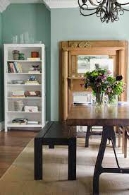 Green dining room with an orange zebra bench designed at a zinc top dining table with a set of orange and green dining chairs. Sage Green Dining Room Remodelista