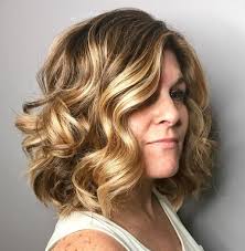 Very old woman having slight curly hair colored in red shade that looks quite lovely short hairstyle that has a neat and fine look secured with an orange clip and side parting. 50 Unrivaled Hairstyles For Women Over 40 Hair Adviser