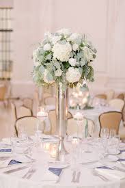 Tall White And Green Arrangement Nestled On Top Of A Silver Trumpet Vase Centerpiece Accented With Floa Wedding Table Flowers Floating Candles Wedding Wedding