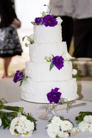 The bride is the image of vintage/boho perfection with her thick red hair, flower crown and lace dress with delicate angel sleeves. Four Tier Buttercream Wedding Cake With Purple Roses