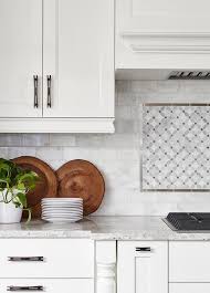 A White Wood Panel Hood Is Fixed To Marble Subway Backsplash Tiles Framing White Wood Paneling White Subway Tiles Kitchen Backsplash Mosaic Backsplash Kitchen