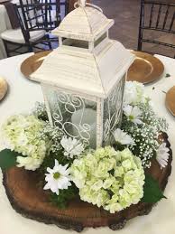 White Lantern Surrounded By Hydrangeas Daisies And Baby S Breath Lantern Centerpiece Wedding Wedding Lanterns White Lanterns Wedding
