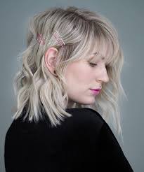 Shoulder Length Black And Blonde Hairstyles Woman With Wavy Blonde Hair With Bangs Wearing Black Blouse Shoulder Length Hair Pink Lip Medium Length Hair Styles Womens Hairstyles Blonde Hair With Bangs
