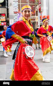 Close up of a Japanese mature women, part of a yosakoi dance team, dancing  with tambourine during the Kyusyu Gassai festival at Kumamoto in Japan  Stock Photo 