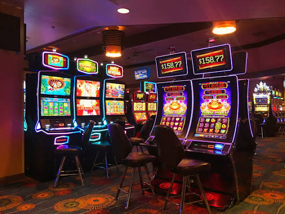 A slot machine in a casino with neon lights - Free Photo on Unsplash