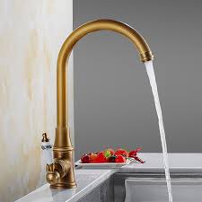 A round gold vanity mirror hangs over a white and gold marble vanity top holding a sink beneath an antique brass vintage waterfall faucet. Swan Neck Kitchen Faucet With Porcelain Handle Solid Brass Tap Chrome Antique Brushed Gold Black