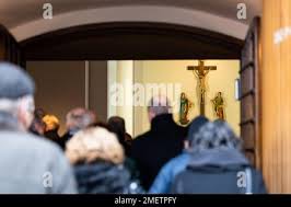 Wolfsburg, Germany. 24th Jan, 2023. Several people stand outside St.  Christopher's Church before the start of the public funeral service for  former VW Group CEO Carl Horst Hahn. Hahn was chairman of