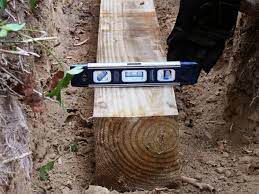 Dig a trench that is about a foot deep and between eight to 10 inches wide (just wide enough to accommodate your timbers of choice). Building A Timber Retaining Wall How Tos Diy